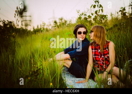 guy and the girl sitting in the grass. Stock Photo