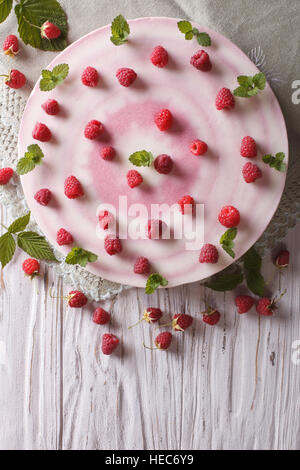 Beautiful cheese cake with fresh raspberries and mint close-up. vertical top view Stock Photo