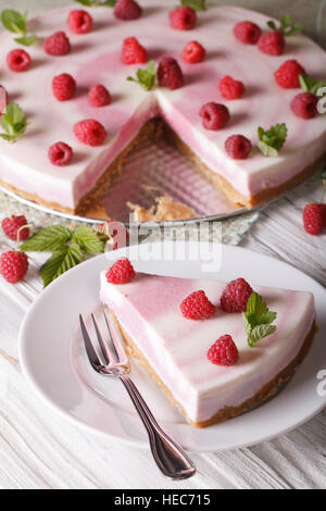 Sliced sweet cheesecake with raspberries and mint close-up. vertical Stock Photo