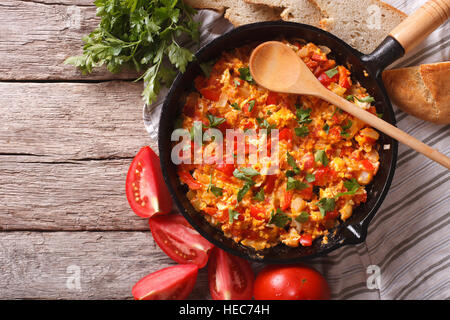 Menemen in a frying pan and ingredients on the table close-up. horizontal view from above Stock Photo