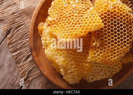 Honeycomb in the wooden plate on the table close-up. horizontal view from above Stock Photo