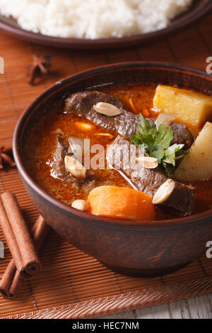 Thai beef massaman curry with peanuts close-up on the table and rice. vertical Stock Photo