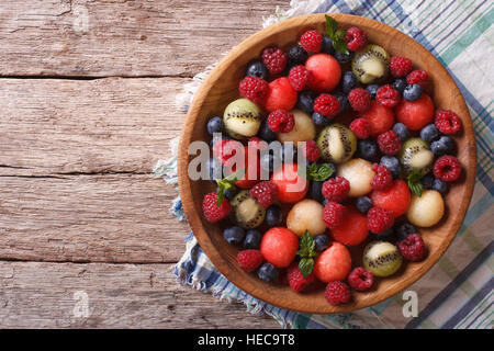salad of blueberries, raspberries, melon and watermelon in a wooden bowl. horizontal view from above Stock Photo