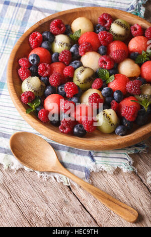 salad of blueberries, raspberries, melon and watermelon in a wooden bowl closeup. rustic style vertical Stock Photo