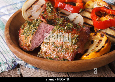 Grilled meat with pesto and vegetables close-up on a plate. Horizontal Stock Photo
