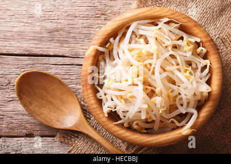 sprouts of mung beans in a wooden bowl on the table. horizontal view from above Stock Photo