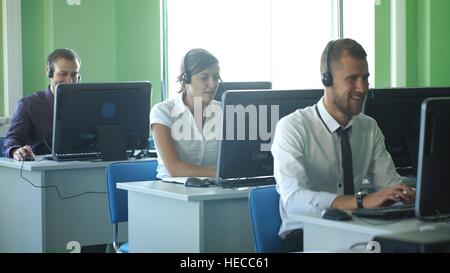 business colleagues with headsets using computers at the m dern office desk Stock Photo