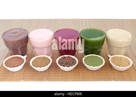 Health food drinks with corresponding  powders of chocolate whey, pomegranate fruit, acai berry, wheatgrass and maca root. Also used by body builders. Stock Photo