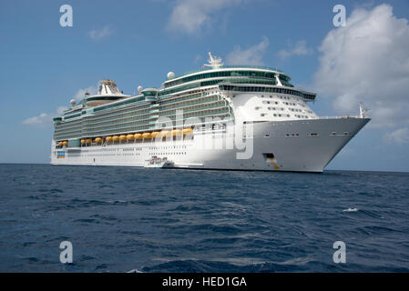 The Royal Caribbean Freedom of the Seas, which carries 4,515 passengers and 1,360 crew, and the Celebrity Reflection, which carries 3,609 passengers and 1271 crew, in the harbor of George Town, Grand Cayman in the Cayman Islands on Tuesday, December 20, 2016.  The smaller boat is a tender to ferry passengers back and forth to the island. Credit: Ron Sachs / CNP /MediaPunch Stock Photo