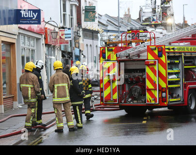 Southsea, Hampshire, UK. 21 December 2016. Fifty Firefighters have been called to tackle a Southsea dry cleaners this morning Ten appliances were called to the Impress launderette in Albert Road just before 6am this morning, Crews from Cosham, Southsea, Fareham, Waterlooville, Portchester and Havant have attended the incident near the Bold Forester Pub. An aerial ladder from St Mary's was brought in to tackle the blaze from above. The blaze took hold of the Impress dry cleaners, next door to the Bold Forester pub in Albert Road, at approximately 6am this morning. Credit: uknip/Alamy Live News Stock Photo