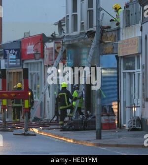 Southsea, Hampshire, UK. 21 December 2016. Fifty Firefighters have been called to tackle a Southsea dry cleaners this morning Ten appliances were called to the Impress launderette in Albert Road just before 6am this morning, Crews from Cosham, Southsea, Fareham, Waterlooville, Portchester and Havant have attended the incident near the Bold Forester Pub. An aerial ladder from St Mary's was brought in to tackle the blaze from above. The blaze took hold of the Impress dry cleaners, next door to the Bold Forester pub in Albert Road, at approximately 6am this morning. Credit: uknip/Alamy Live News Stock Photo