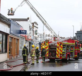 Southsea, Hampshire, UK. 21 December 2016. Fifty Firefighters have been called to tackle a Southsea dry cleaners this morning Ten appliances were called to the Impress launderette in Albert Road just before 6am this morning, Crews from Cosham, Southsea, Fareham, Waterlooville, Portchester and Havant have attended the incident near the Bold Forester Pub. An aerial ladder from St Mary's was brought in to tackle the blaze from above. The blaze took hold of the Impress dry cleaners, next door to the Bold Forester pub in Albert Road, at approximately 6am this morning. Credit: uknip/Alamy Live News Stock Photo