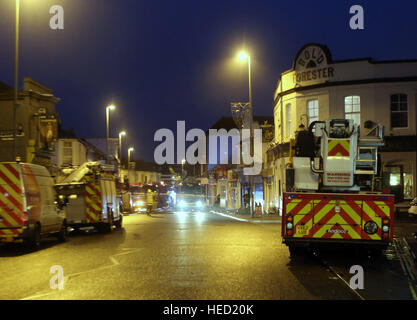 Southsea, Hampshire, UK. 21 December 2016. Fifty Firefighters have been called to tackle a Southsea dry cleaners this morning Ten appliances were called to the Impress launderette in Albert Road just before 6am this morning, Crews from Cosham, Southsea, Fareham, Waterlooville, Portchester and Havant have attended the incident near the Bold Forester Pub. An aerial ladder from St Mary's was brought in to tackle the blaze from above. The blaze took hold of the Impress dry cleaners, next door to the Bold Forester pub in Albert Road, at approximately 6am this morning. Credit: uknip/Alamy Live News Stock Photo