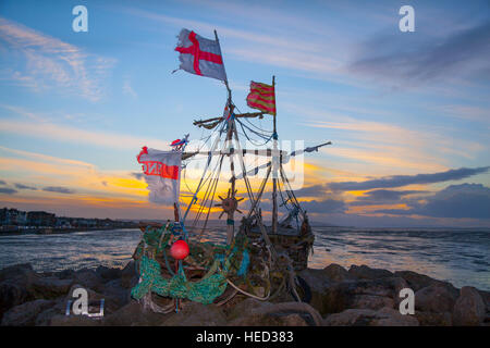 Hoylake, The Wirral, UK.  Uk Weather. 21st December, 2016. Strong Blustery winds on the west coast as the flags of the driftwood Pirate ships signal the onset of storm Barbara. Storm Barbara is predicted for the early hours of Saturday morning, set to batter parts of UK and disrupt Christmas travel. Credit: MediaWorldImages/Alamy Live News Stock Photo