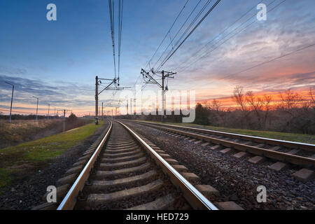 Railway station against beautiful sky at sunset. Industrial landscape with railroad and colorful. Railway junction Stock Photo