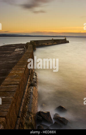 Sea wall at Burghead harbour, Moray, Scotland at sunset Stock Photo