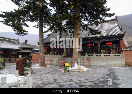 Taihuai: Wutai Shan, one of the four sacred mountains of Buddhism in China; Dailuo Temple; Monk burning an incense stick, Shanxi, China Stock Photo