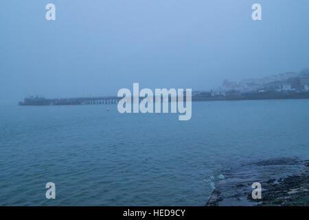 Looking across the bay through the fog at the long pier Stock Photo