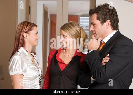 Three young businesspeople having a conversation, discussing Stock Photo