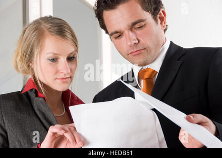 Two young businesspeople looking over documents Stock Photo