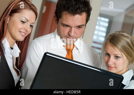 Three young businesspeople working on a laptop Stock Photo