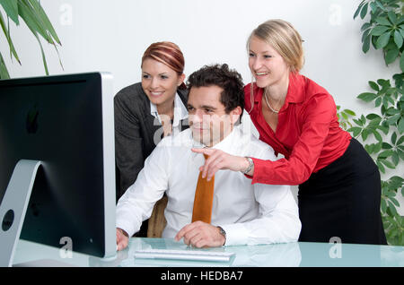 Three young businesspeople working on the computer, in an office Stock Photo