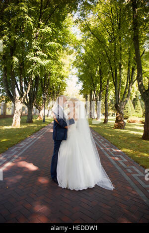 Newlyweds tenderly embraced in the park Stock Photo