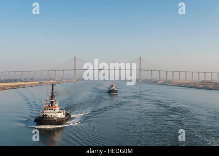 Tug Boats pass the Suez Canal Bridge at El Qantara, Egypt Stock Photo