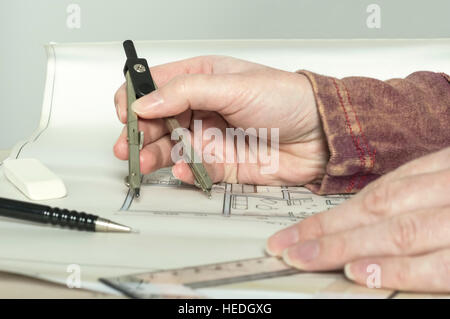 Architect hands holding divider and ruler while working on construction engineering project blueprint.  Construction concept. Stock Photo