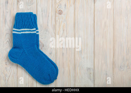 Knitted wool socks blue color on light wooden background. Stock Photo