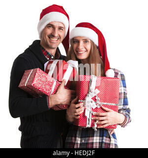 Happy couple in santa hats holding christmas gift boxes isolated on white background Stock Photo