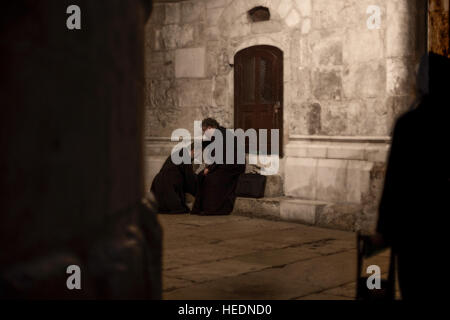 Jerusalem, Israel - November 3, 2013: Two Orthodox priests during their confession at the back of the Rotunda in Holy Sepulchre in Jerusalem. Stock Photo