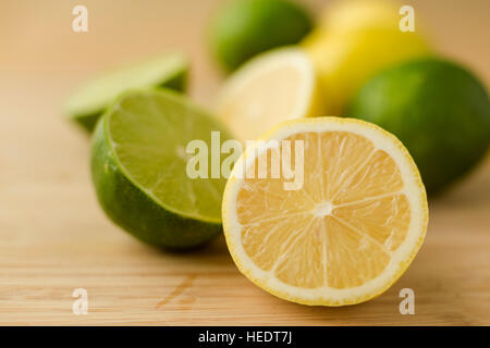 Sliced halves of lemons and limes on a cutting board. Stock Photo