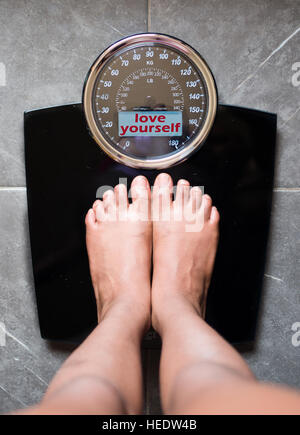 the bathroom scales that speaks to you and tells you the truth by writing it on the screen: love yourself Stock Photo