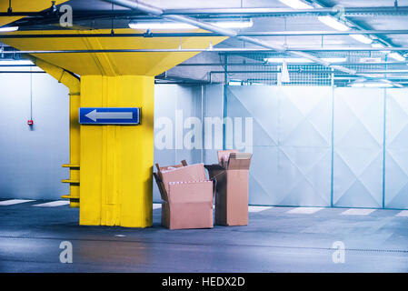 Empty cardboard boxes in underground garage parking lot, urban exploration Stock Photo