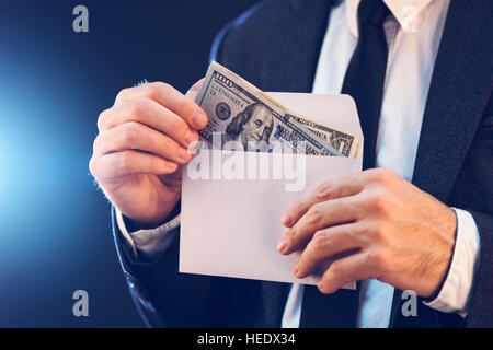 Bribery and corruption concept in business and politics with caucasian businessman and cash money in white envelope Stock Photo