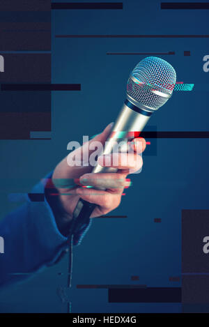 Female journalist conducting business interview or press conference, hand with microphone, digital glitch effect Stock Photo