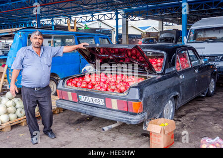 BAKU, AZERBAIJAN - SEPTEMBER 24: Man selling ripe pomegranates from his old Lada car at local wholesale market in Baku, Azerbaijan Stock Photo