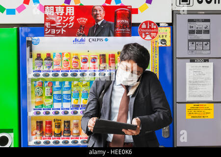 Japan, Honshu, Tokyo, Young Businessman on Mobile Phone and Computer Stock Photo