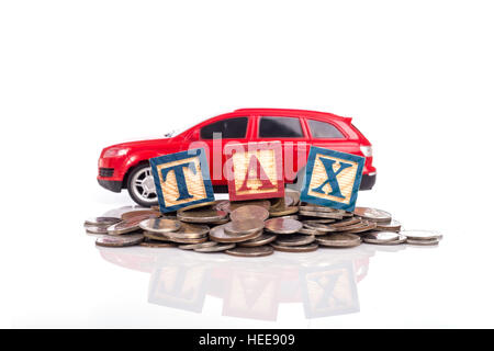 TAX write in colorful wood alphabet blocks  with red model car and stack of coin isolated on white background Stock Photo