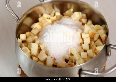 Adding sugar into apple filling. Making Filo Pastry Topped Apple Pie Series. Stock Photo