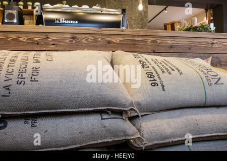 Sacks of fresh Brazilian coffee beans stacked by cafe counter in Bergbrand Rosterei coffee shop. Nuremberg, Bavaria, Germany Stock Photo