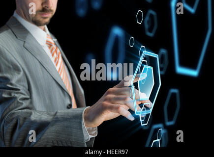 Businessman touching button on futuristic virtual screen, black background Stock Photo