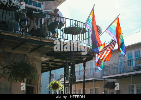 Gay pride flags blowing in the wind on the balcony of a New Orleans cafe. Stock Photo