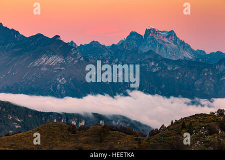 Profiles of the Prealpi Venete at dawn. Behind Monte Pelmo peak. Dolomiti Bellunesi. Italy. Europe. Stock Photo