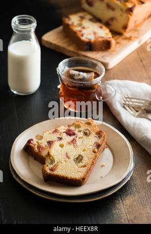 Cake with grapes and plums, sliced on plate over rustic background, selective focus Stock Photo
