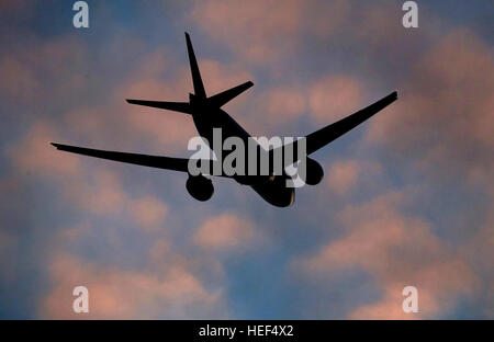 The sun sets as a plane takes off from London Stansted Airport in Essex. Stock Photo