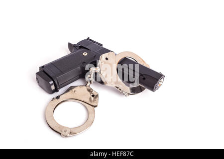 Close up gun and handcuffs isolated on white background Stock Photo