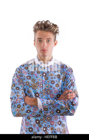 Young blond stylish man dressed in a floral seventies inspired blue, brown and white shirt Stock Photo