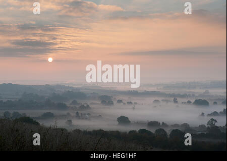 Dawn sunrise over Northdowns valley looking towards Mereworth Woods Charing Hills mist being burnt off by rising sun autumn Stock Photo